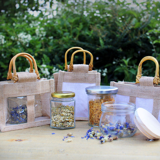 Rustic natural jute gift bag with three transparent windows and sturdy handles for carrying jars.