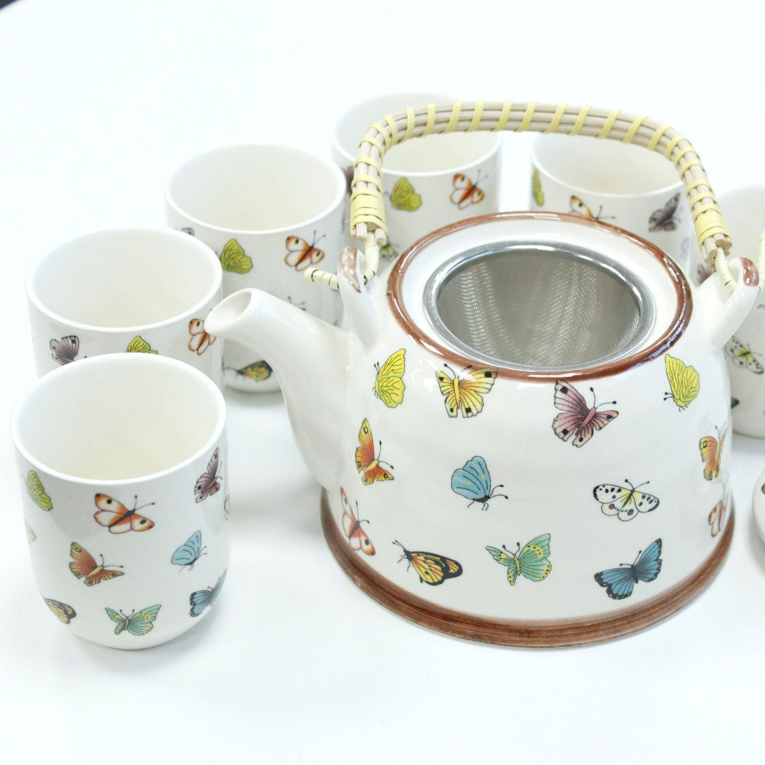 Elegant white ceramic teapot and six matching tea cups featuring a delicate blue and orange butterfly design.