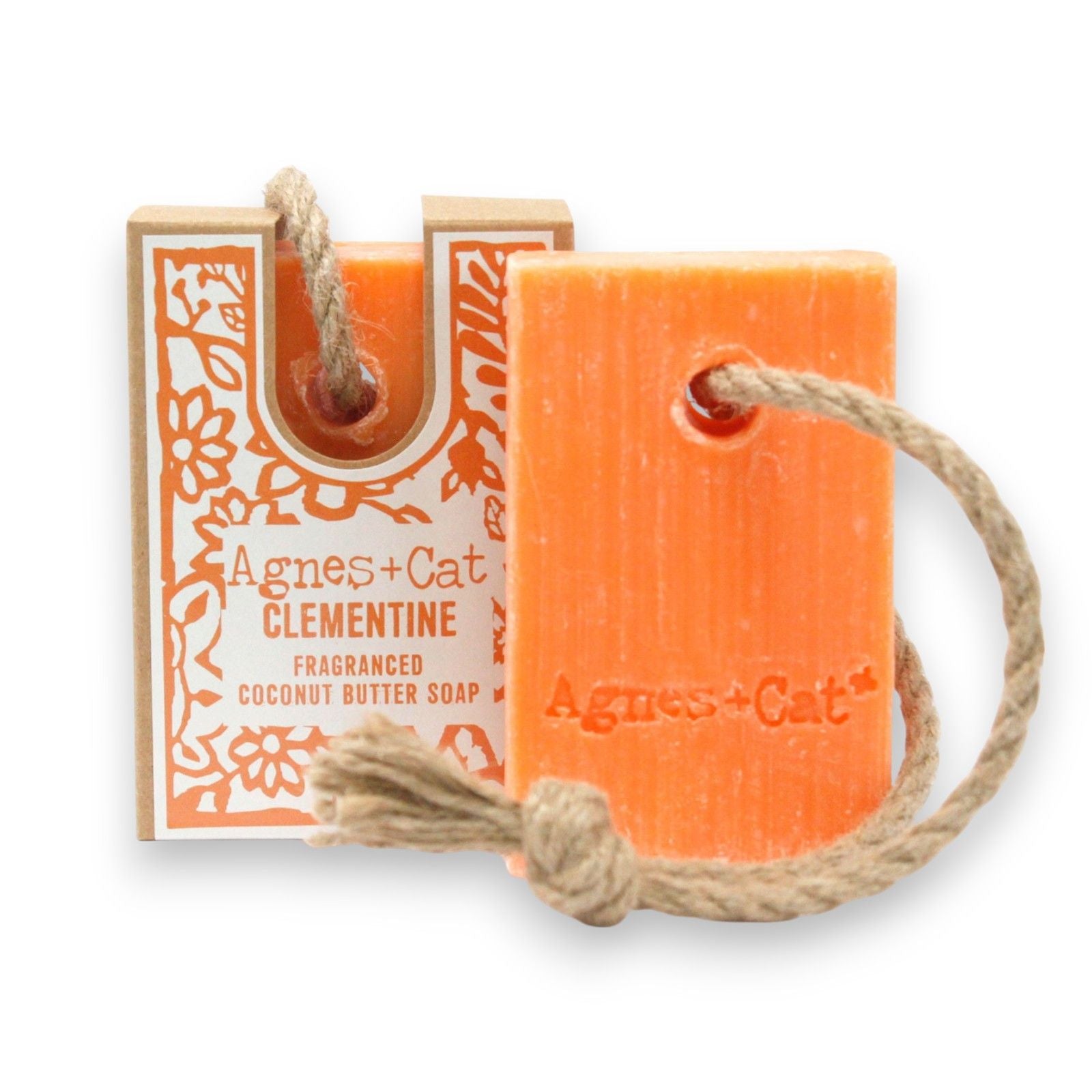 Handcrafted orange-toned soap on a natural rope with a textured surface for a rustic wellness look.