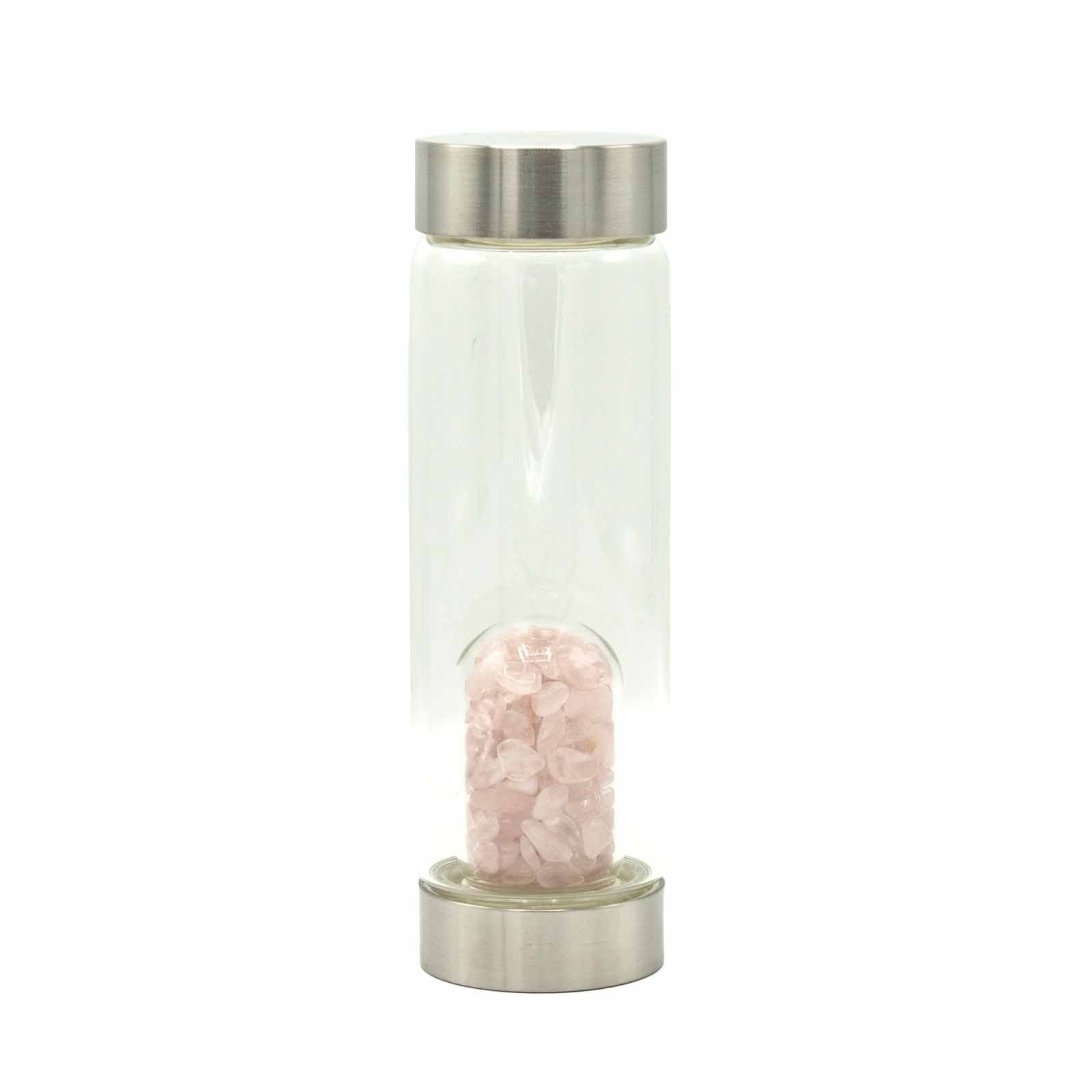 Clear glass water bottle filled with light pink rose quartz crystal chips at the base.