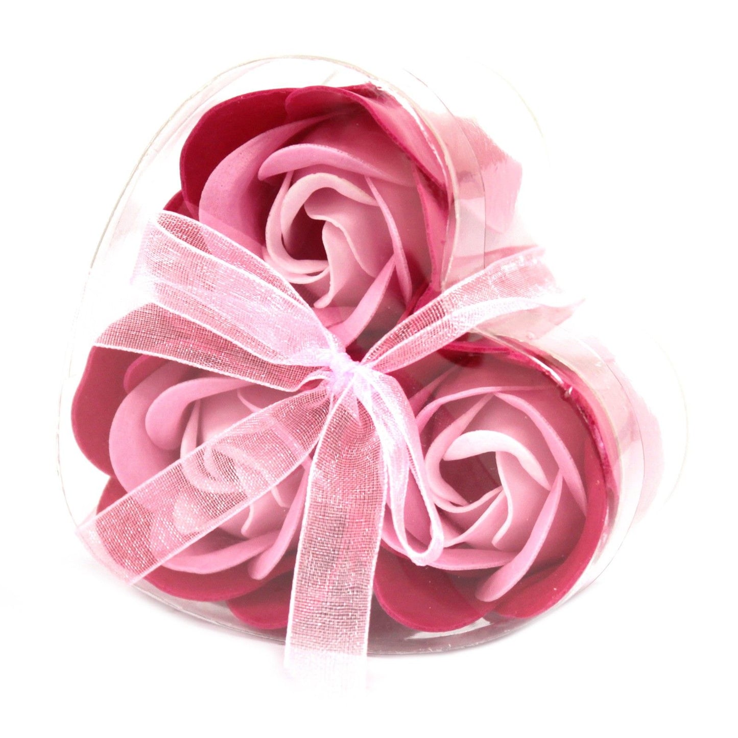 Three delicate pink soap roses arranged in a heart-shaped gift box for a luxury bath experience.