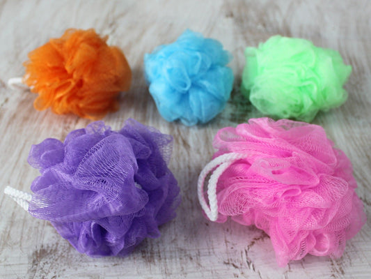 A soft, mesh bath scrunchie in an assorted vibrant colour, designed for creating a rich lather during bathing.