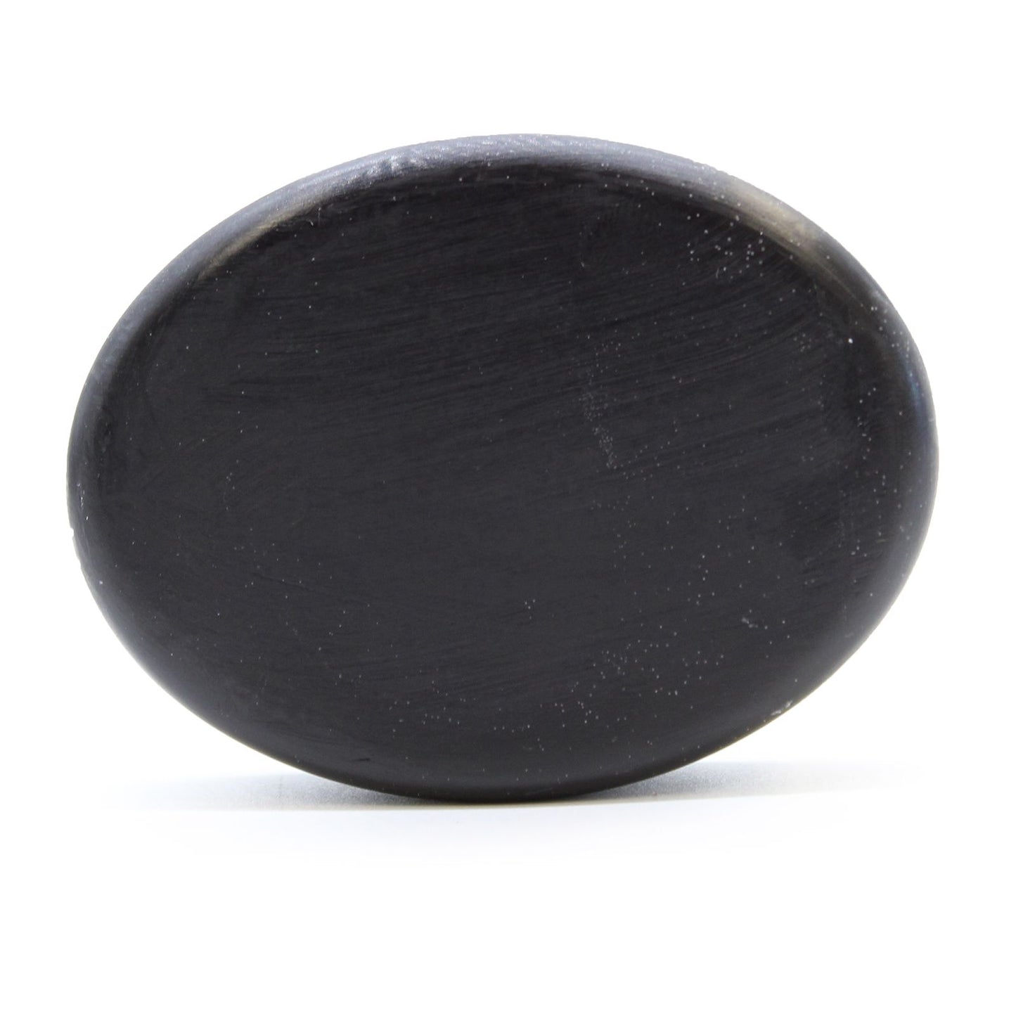 Dark grey textured charcoal soap bar with natural botanical infusions on a neutral background.