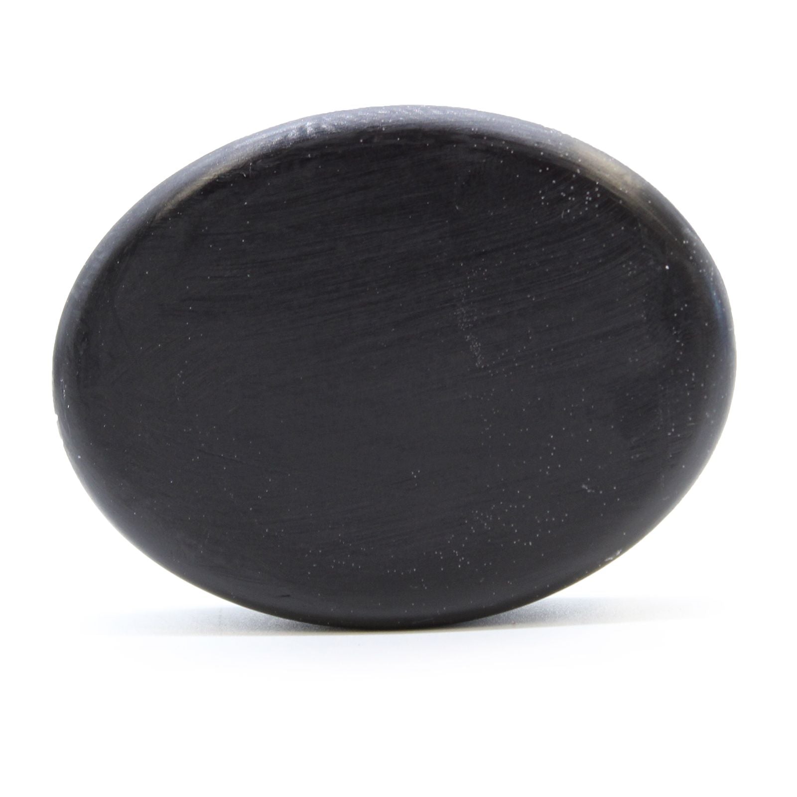 Dark grey textured charcoal soap bar with natural botanical infusions on a neutral background.