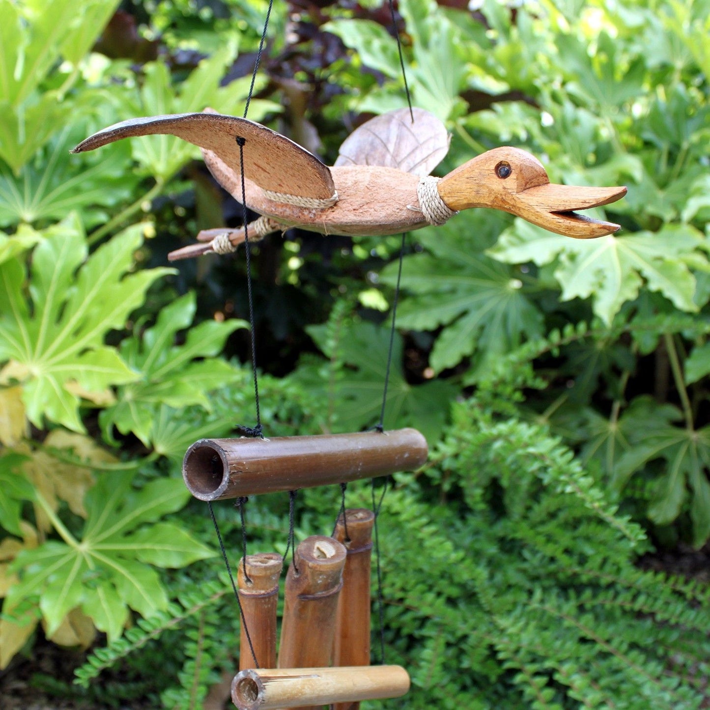 Handcrafted bamboo wind chime featuring a carved coconut duck hanging from a natural wood frame with hollow bamboo tubes.