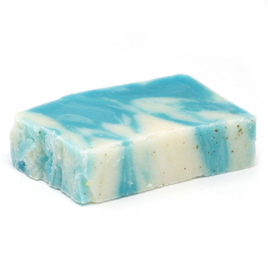 Textured green artisan soap slice infused with seaweed pieces, showing a rustic cold-process finish.
