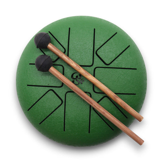 Small circular green steel tongue drum with an engraved Om symbol and matching mallets on a neutral background.