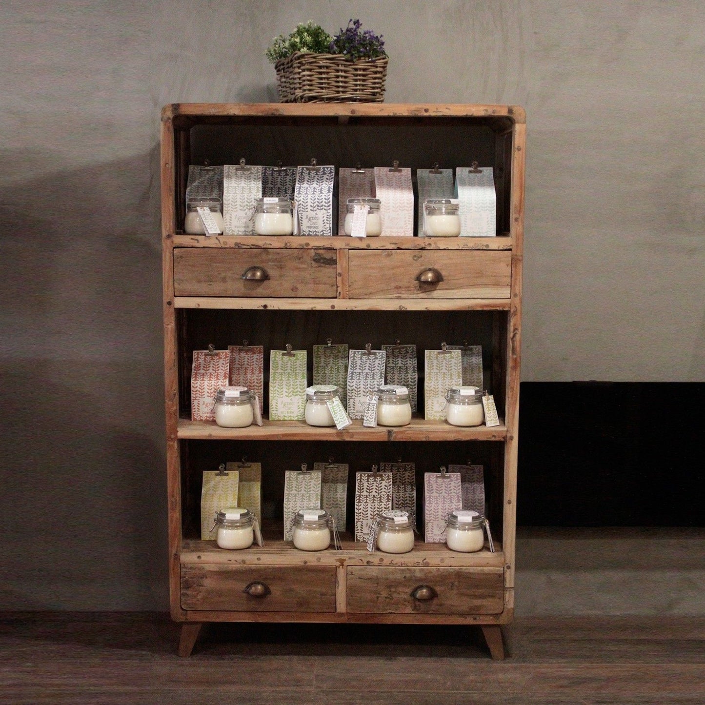 Tall rustic shelving unit made from upcycled multi-coloured teak wood with three open shelves and four small drawers.