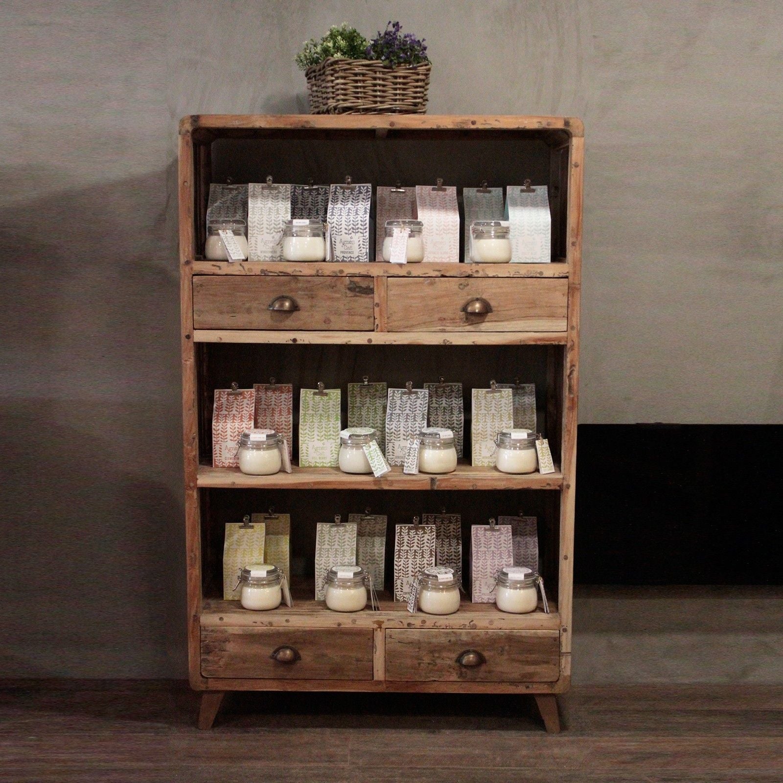 Tall rustic shelving unit made from upcycled multi-coloured teak wood with three open shelves and four small drawers.