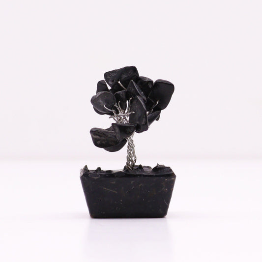 Miniature gemstone tree with black agate leaves on a decorative orgonite base.