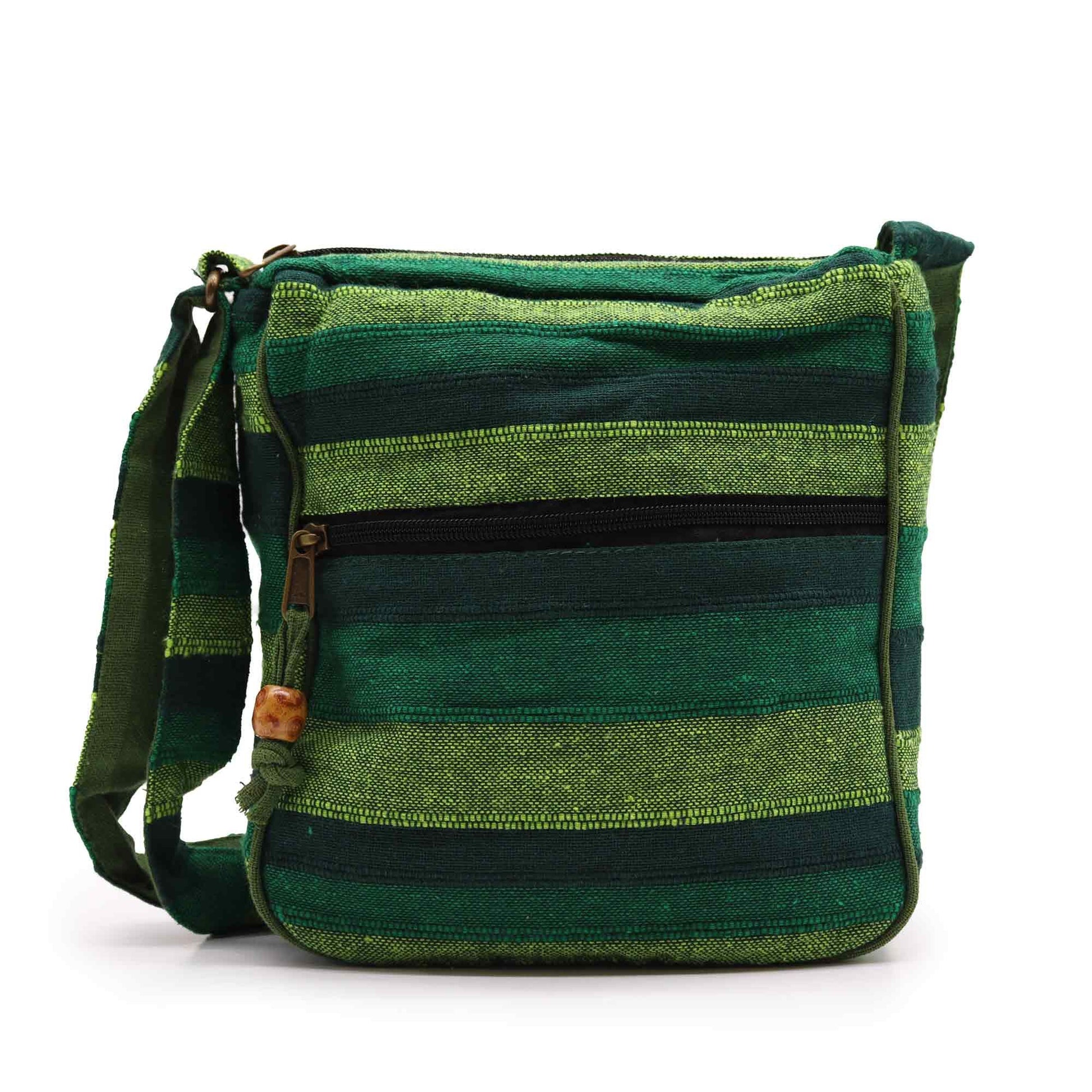 Large forest green canvas sling bag with an adjustable strap and front pocket detailing.