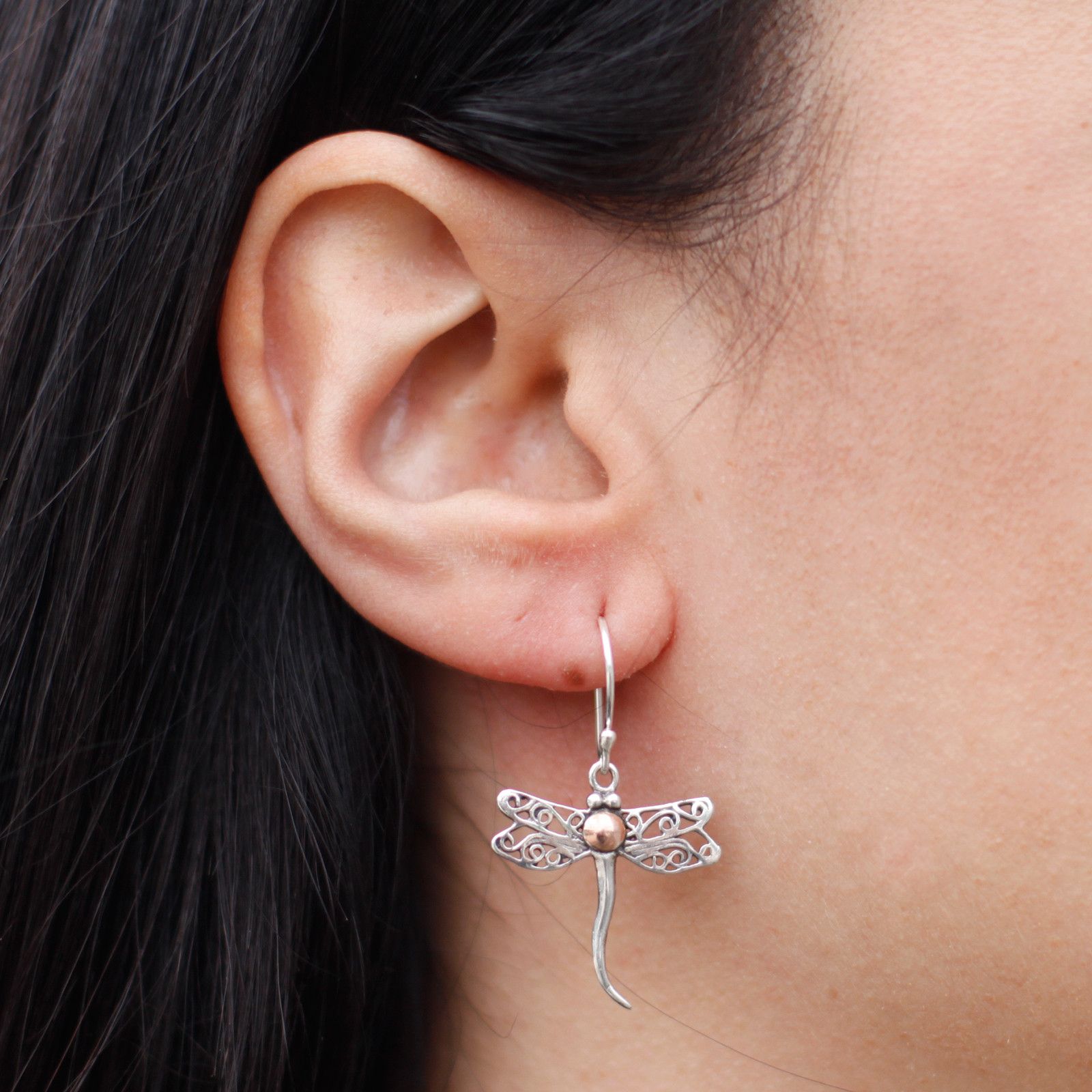 Intricate dragonfly shaped earrings featuring a mix of polished silver and gold tones.