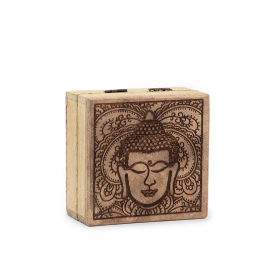 Small square black wooden box featuring an intricate engraved Buddha face design on the lid.