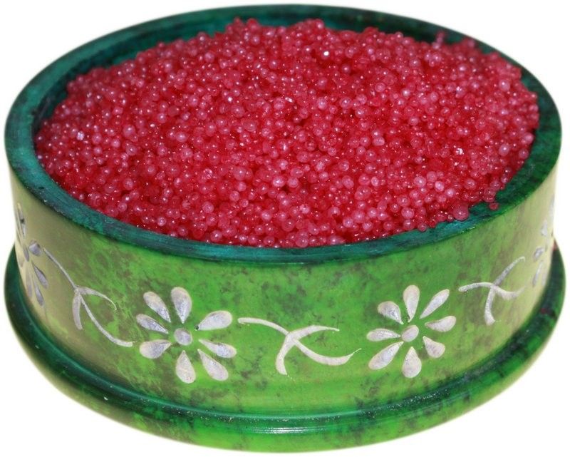 Pile of vibrant red cranberry scented simmering granules for oil burners.