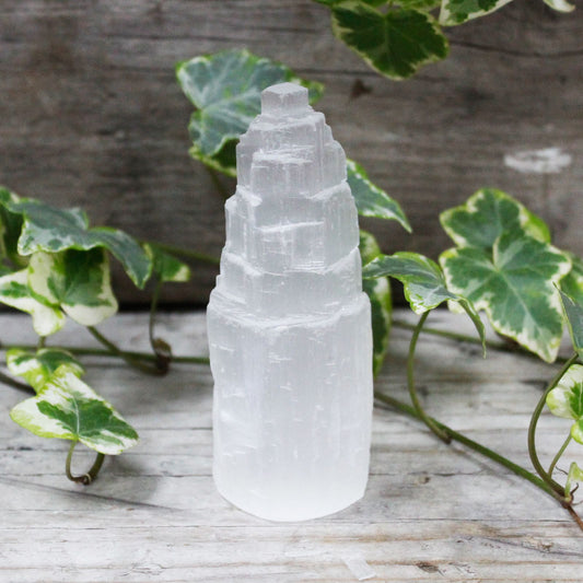 A 10cm tall natural selenite crystal tower with a translucent white finish and vertical striations.