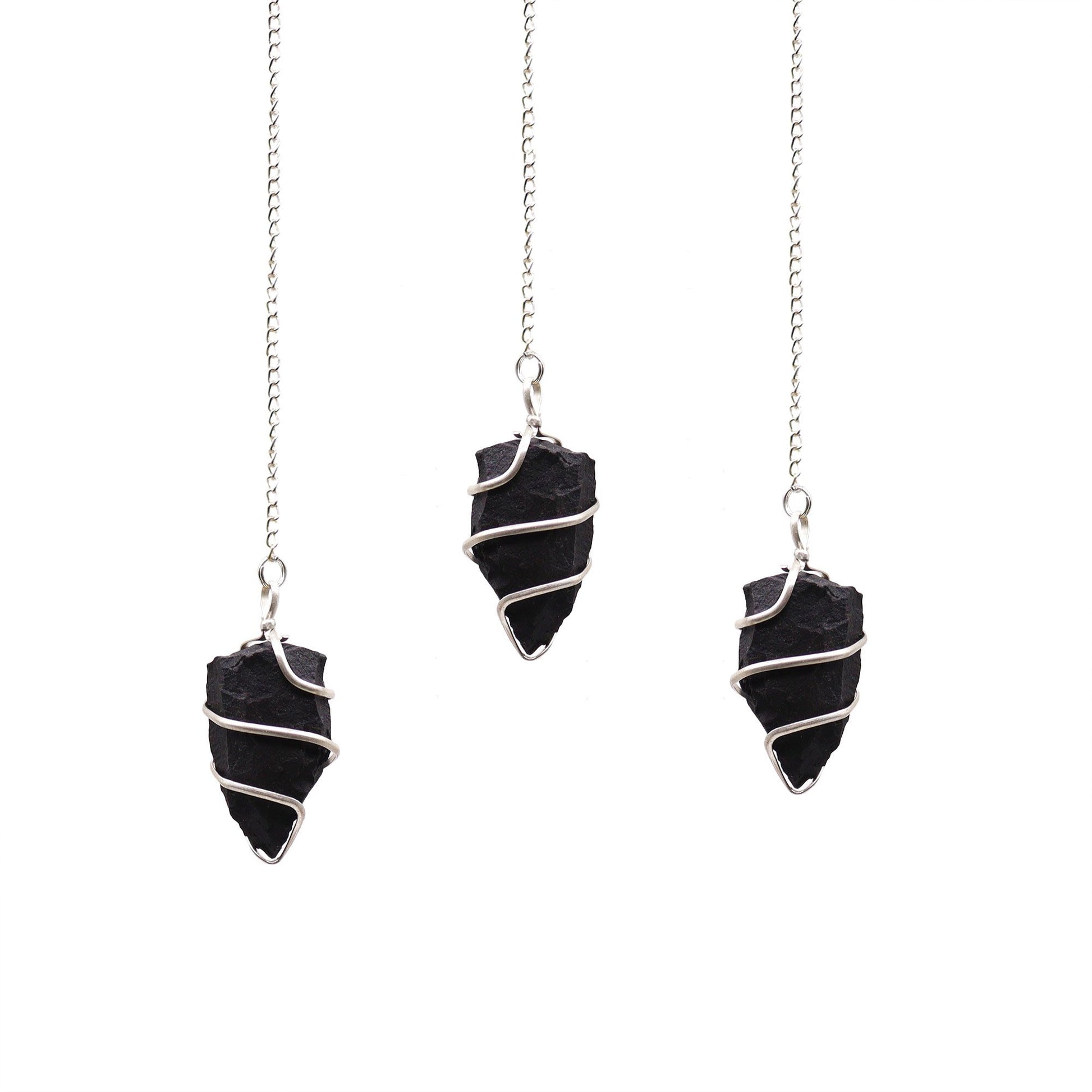 Raw black agate gemstone pendulum with a natural jagged texture suspended from a silver-toned chain.