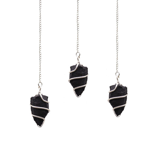 Raw black agate gemstone pendulum with a natural jagged texture suspended from a silver-toned chain.