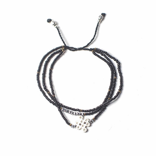 Handcrafted adjustable red string bracelet featuring a small silver sacred symbol charm.