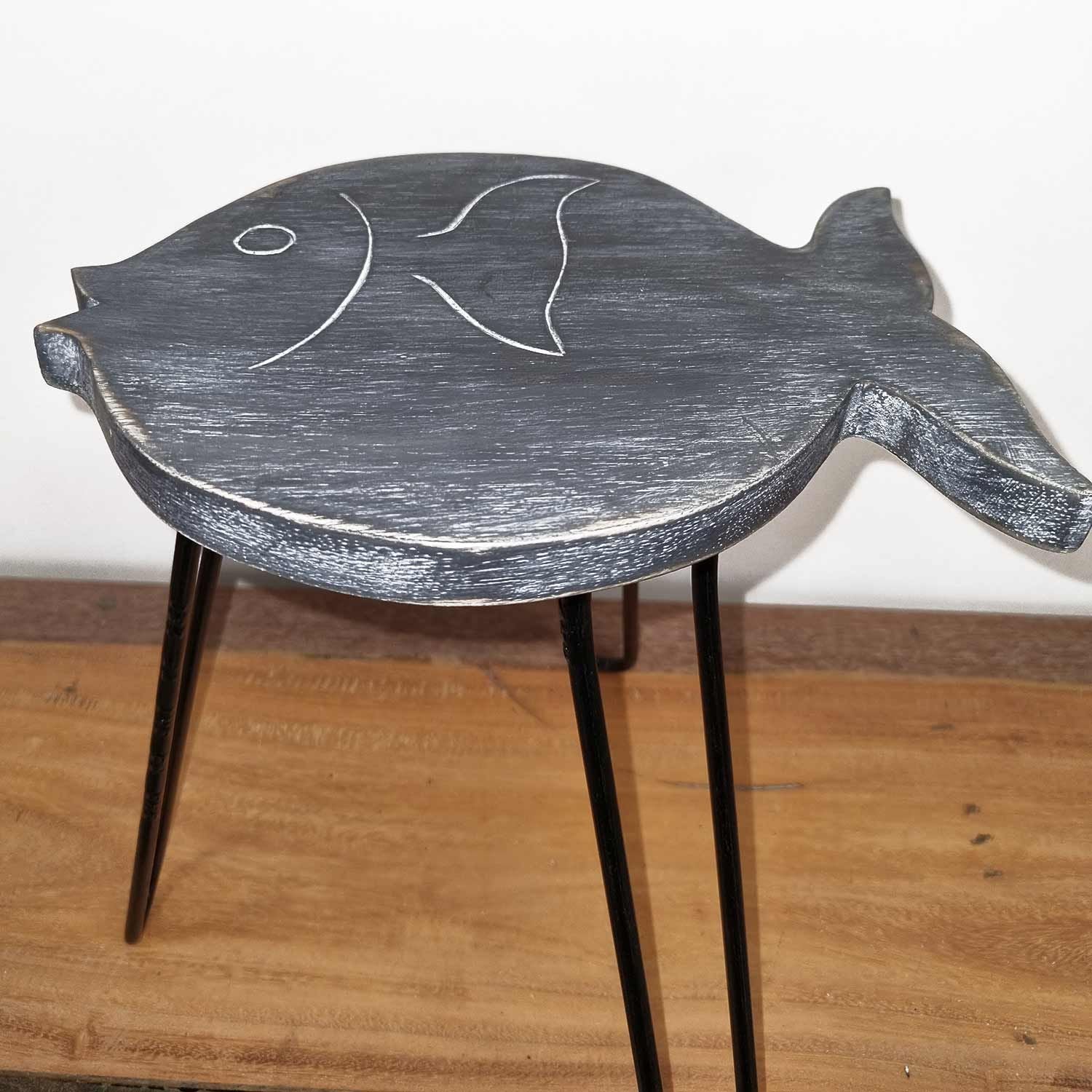 Handcrafted fish-shaped wooden plant stand with a rustic greywash finish and sturdy legs for displaying indoor plants.