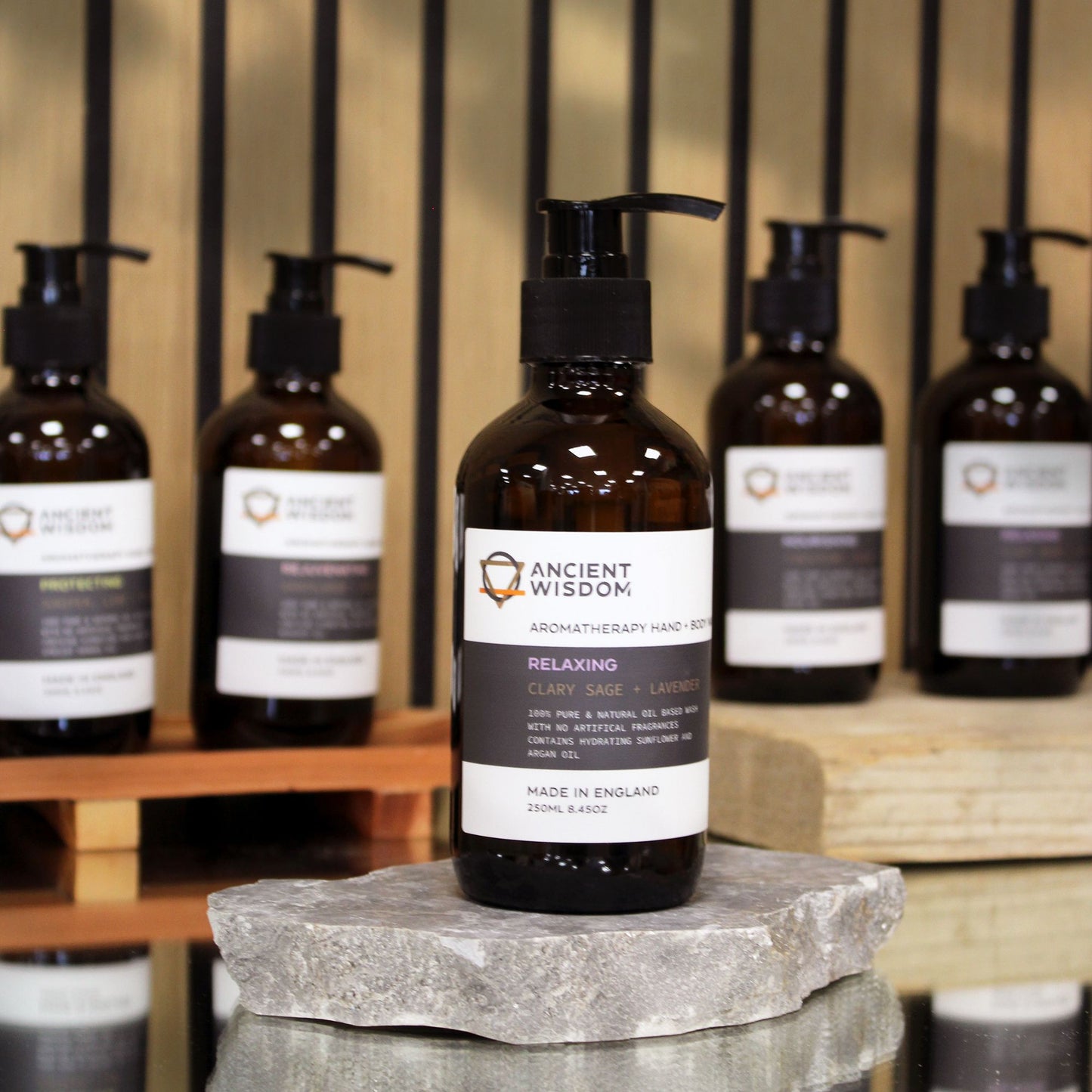 Clear 250ml bottle of amber-coloured liquid hand and body wash with a black pump dispenser.