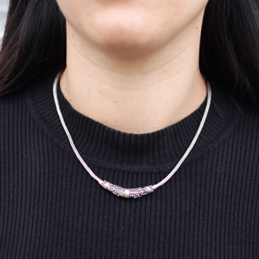 Elegant mixed metal necklace featuring a combination of silver and gold tribal-inspired elements on a delicate chain.