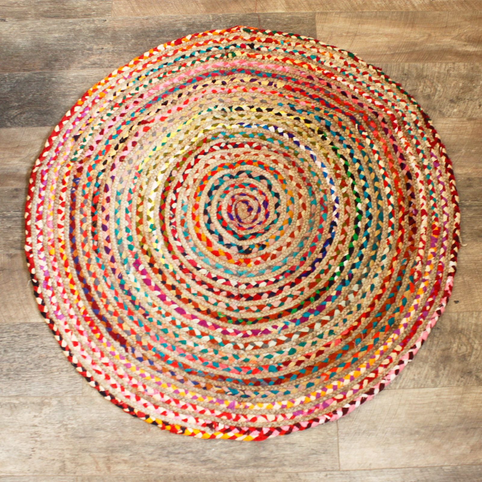 Hand-made round rug featuring a braided texture of natural jute fibers and colourful recycled cotton sari fabric.