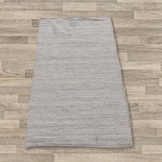 Handwoven small rectangular cotton rug in a soft grey shade with a subtle textured weave.