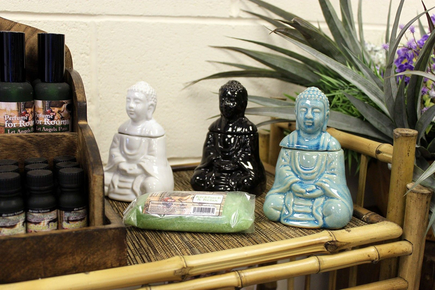 Serene blue glazed ceramic oil burner shaped like a sitting Buddha with a tealight candle holder base.