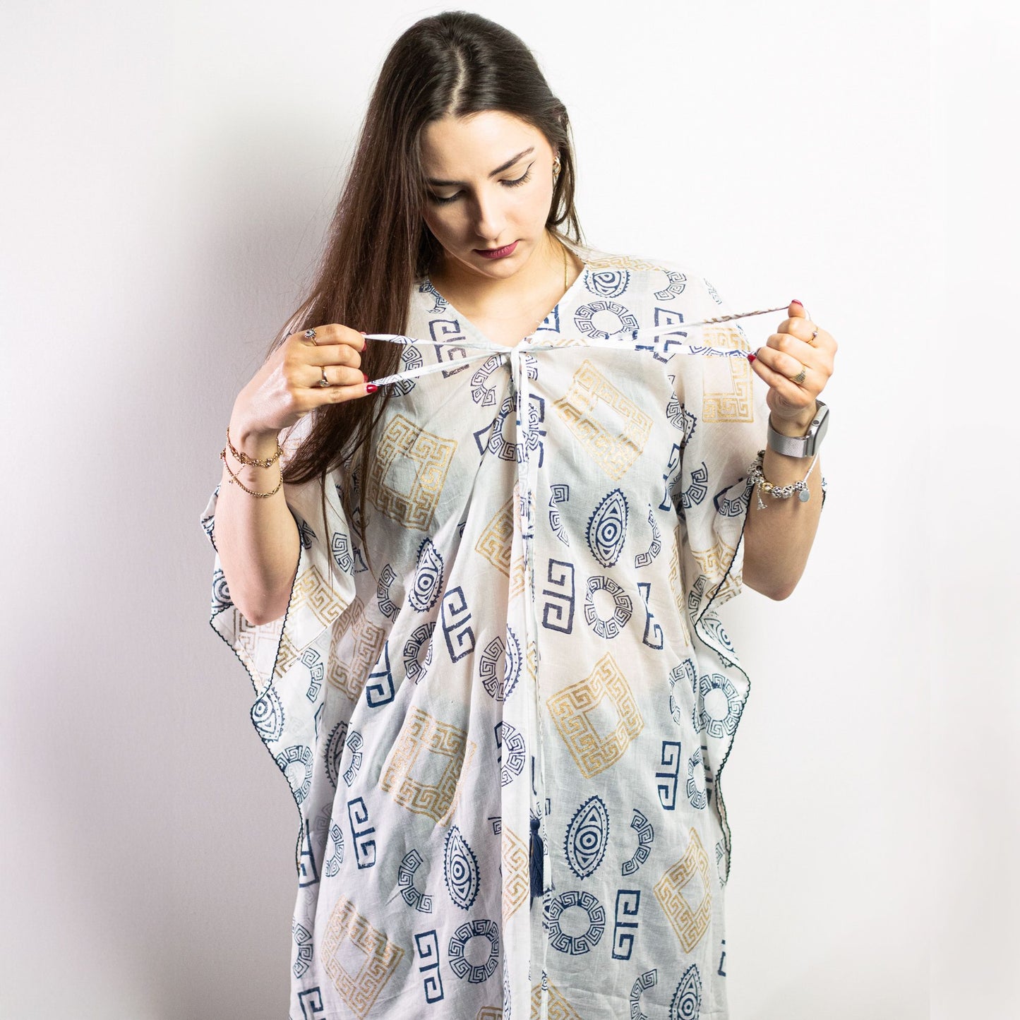 Flowing white cotton kaftan featuring handpainted Mediterranean Greek motifs in vibrant blue and shimmering gold.