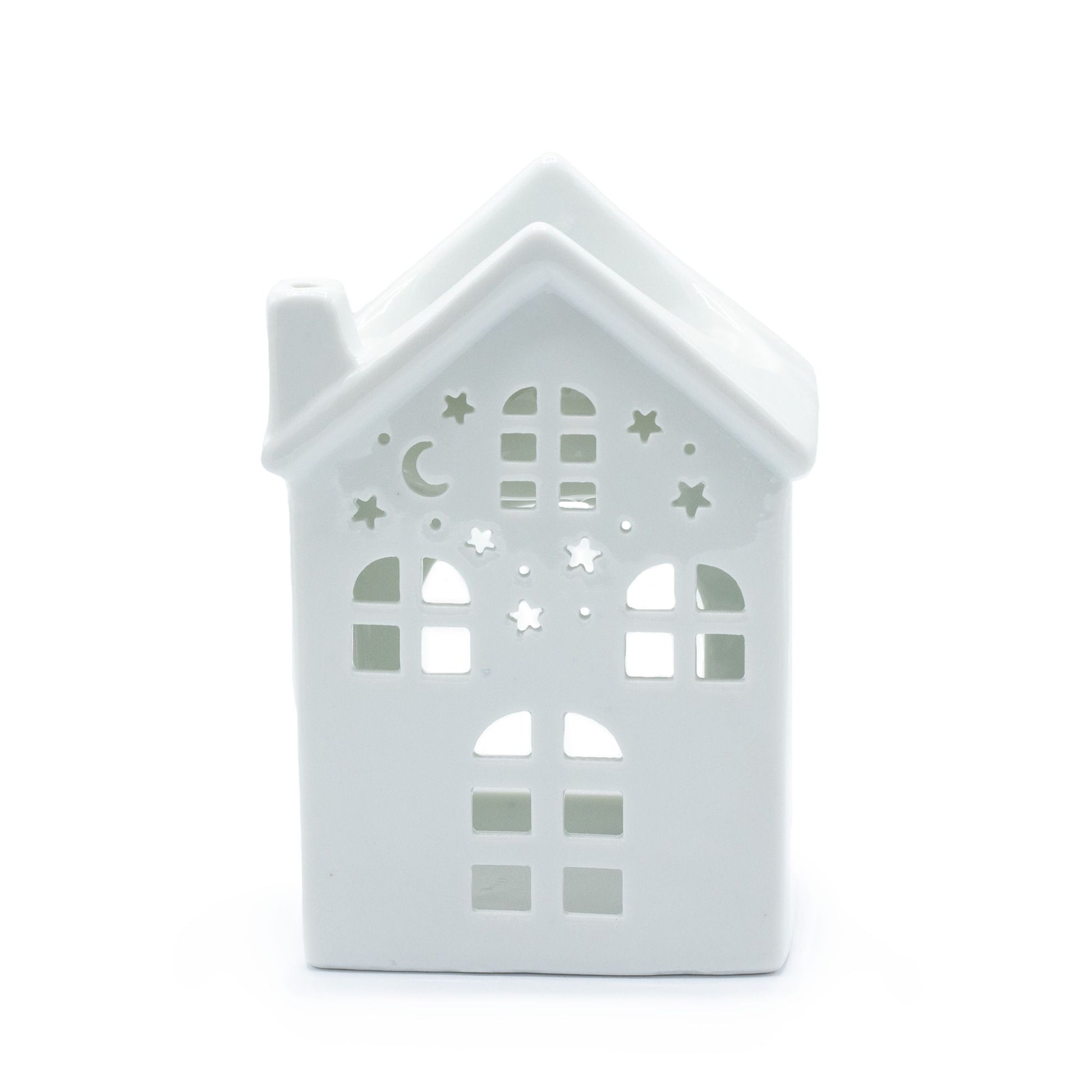 White ceramic oil burner with a decorative house-shaped cutout design and a tea light candle holder base.