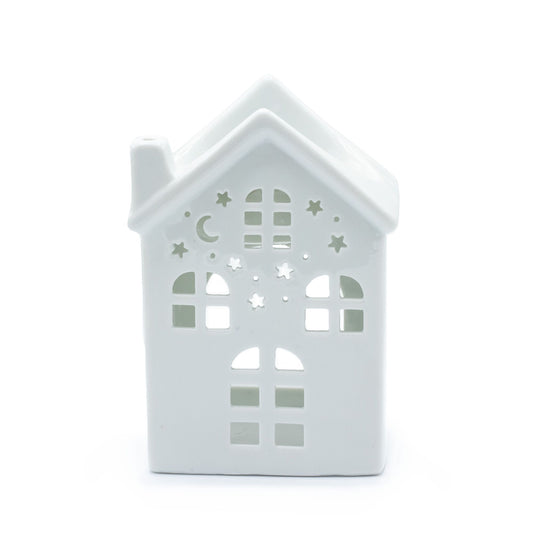 White ceramic oil burner with a decorative house-shaped cutout design and a tea light candle holder base.