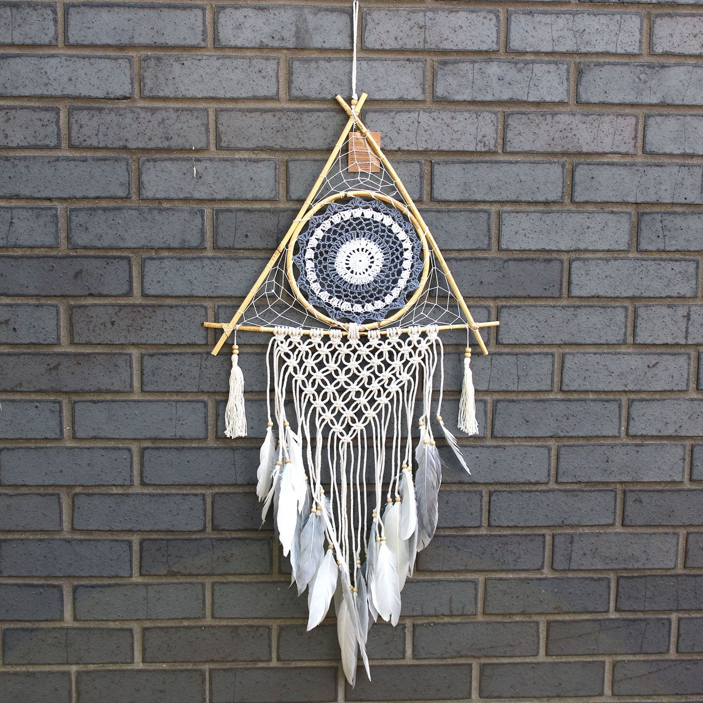 Large white and grey macrame dream catcher in a unique pyramid shape featuring a protective blue evil eye symbol.