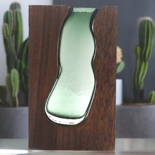 Large cylindrical glass vase nestled inside a tall, rectangular dark tung wood frame for modern botanical displays.