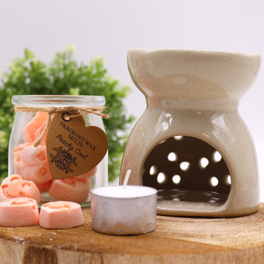 Elegant ivory ceramic oil burner featuring a detailed cut-out Tree of Life design and a glossy glazed finish.