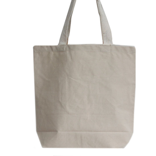 Large rectangular plain eco-friendly cotton tote bag with long shoulder handles shown in a neutral minimalist setting.