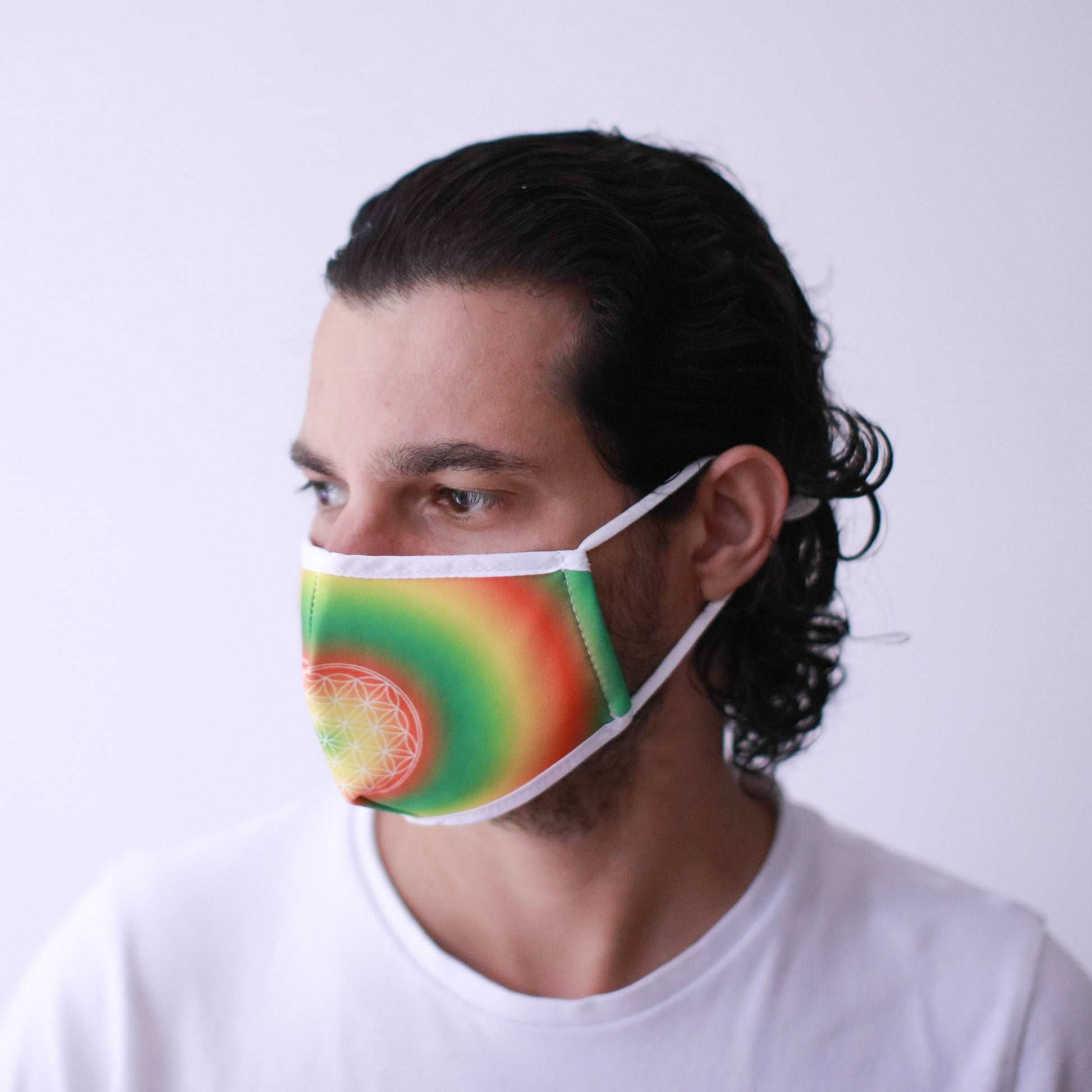 Adult reusable fabric face mask featuring a colourful sacred geometry Flower of Life pattern on a dark background.