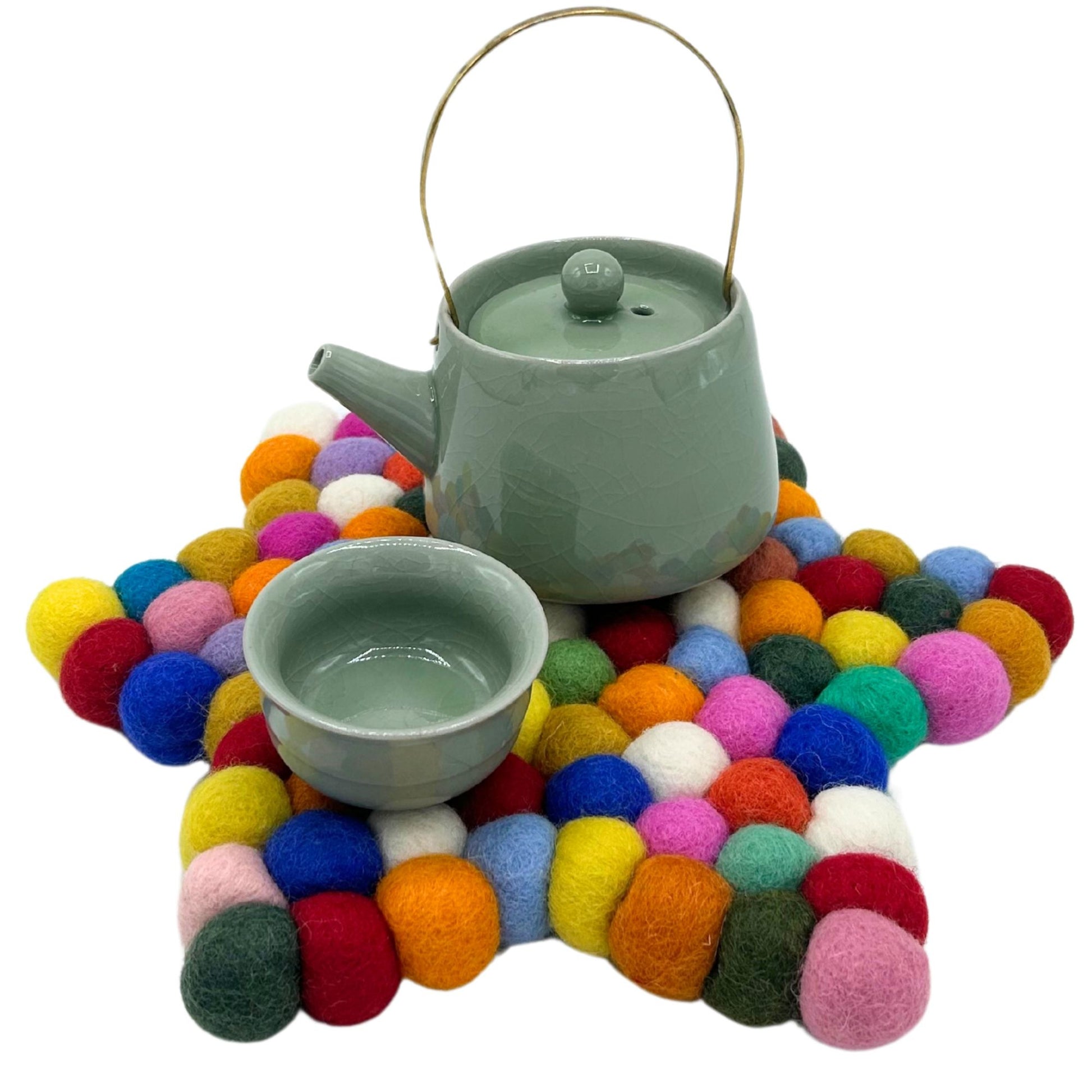 Handcrafted star-shaped centre mat made from vibrant, multi-coloured felt balls arranged in a decorative pattern.