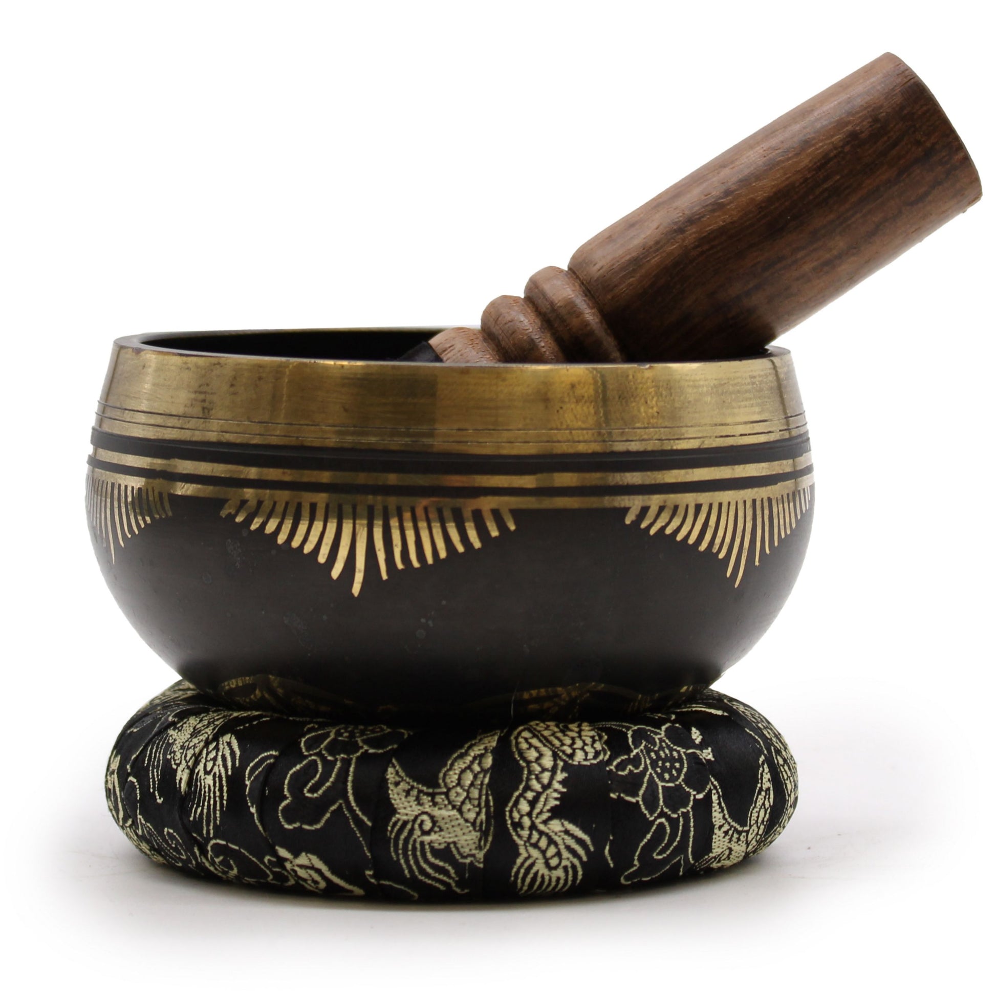 Handcrafted brass singing bowl with an engraved Flower of Life symbol, resting on a cushion with a wooden mallet.