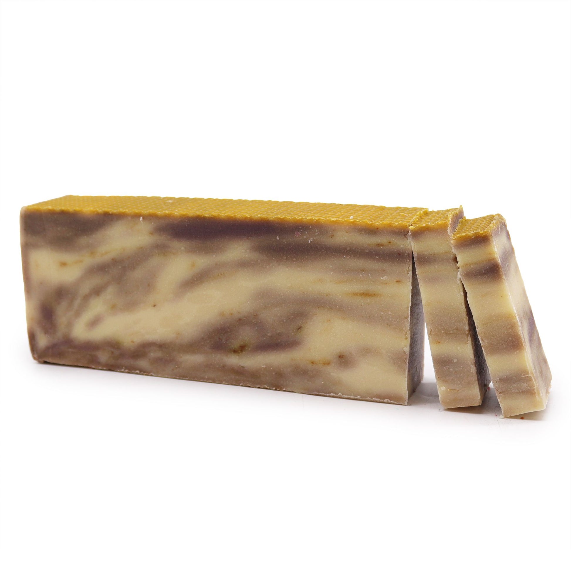Handcrafted olive oil soap loaf infused with natural propolis, showing a rustic textured surface and rich golden tone.