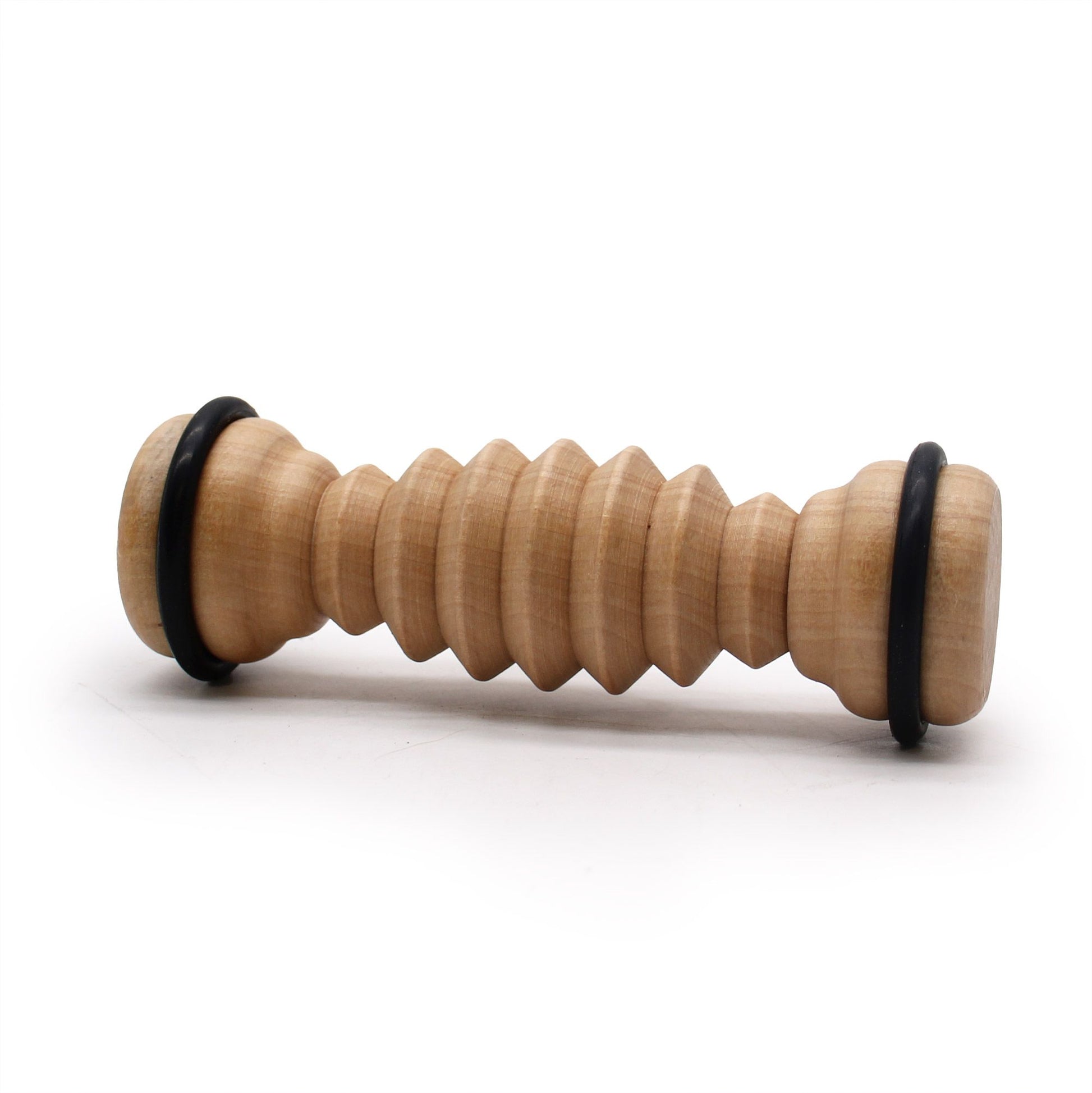 Compact ribbed wooden foot roller made from smooth hemu wood for reflexology and foot massage.