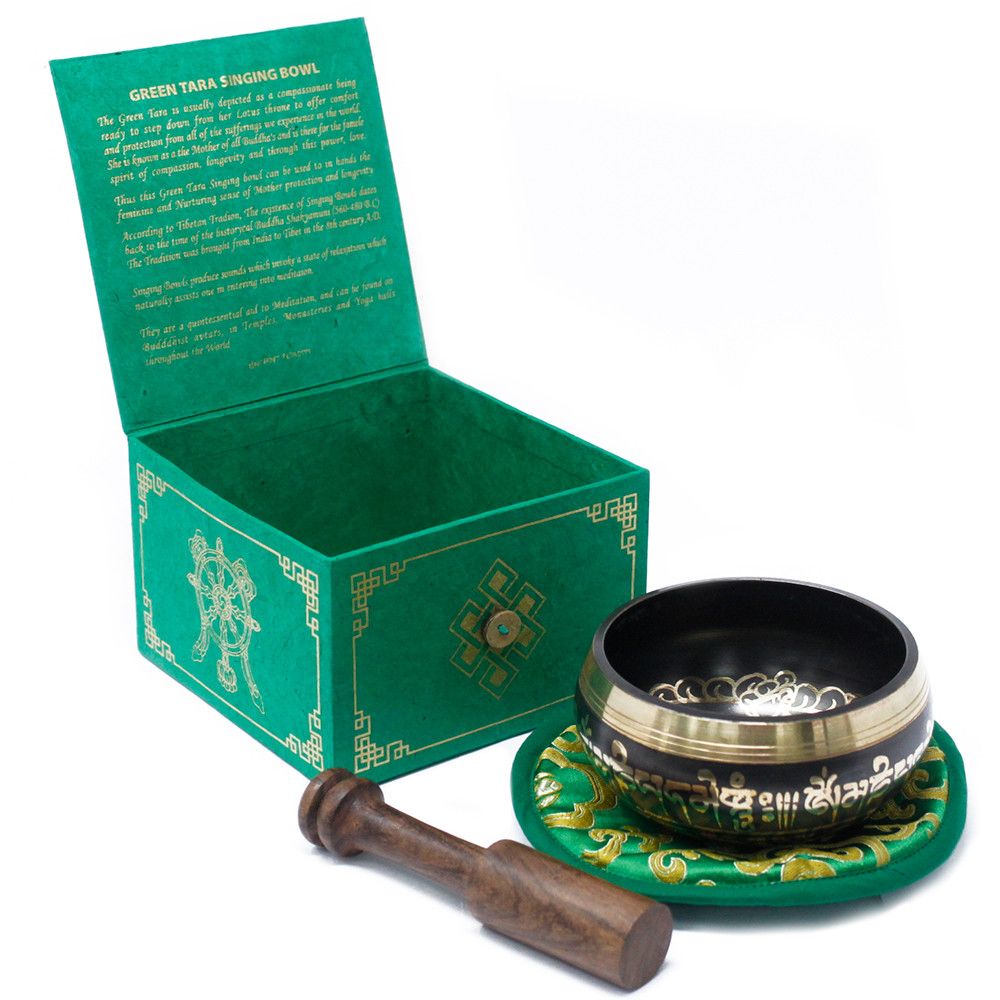 Handcrafted brass singing bowl with detailed Green Tara engravings, wooden striker, and cushion.