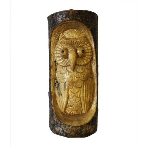 Detailed hand-carved wooden owl nested inside a rustic natural tree trunk section.