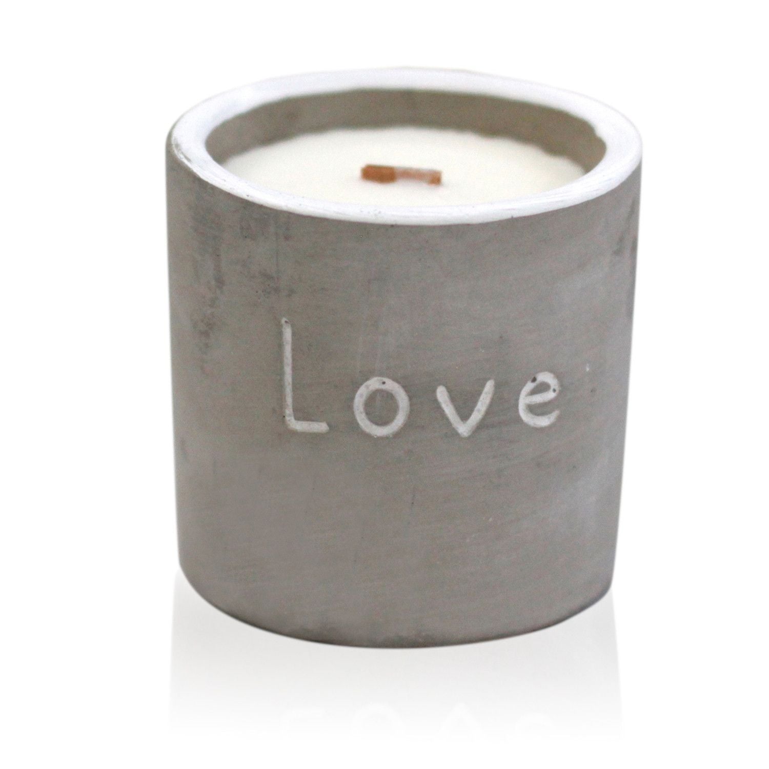 Hand-poured purple fig and casis scented candle in a textured grey concrete pot with a natural wooden wick.