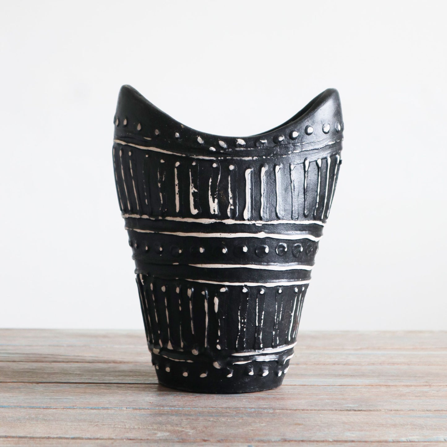Handcrafted chocolate brown ceramic vase with a unique swirl shape and textured terracotta patterns.