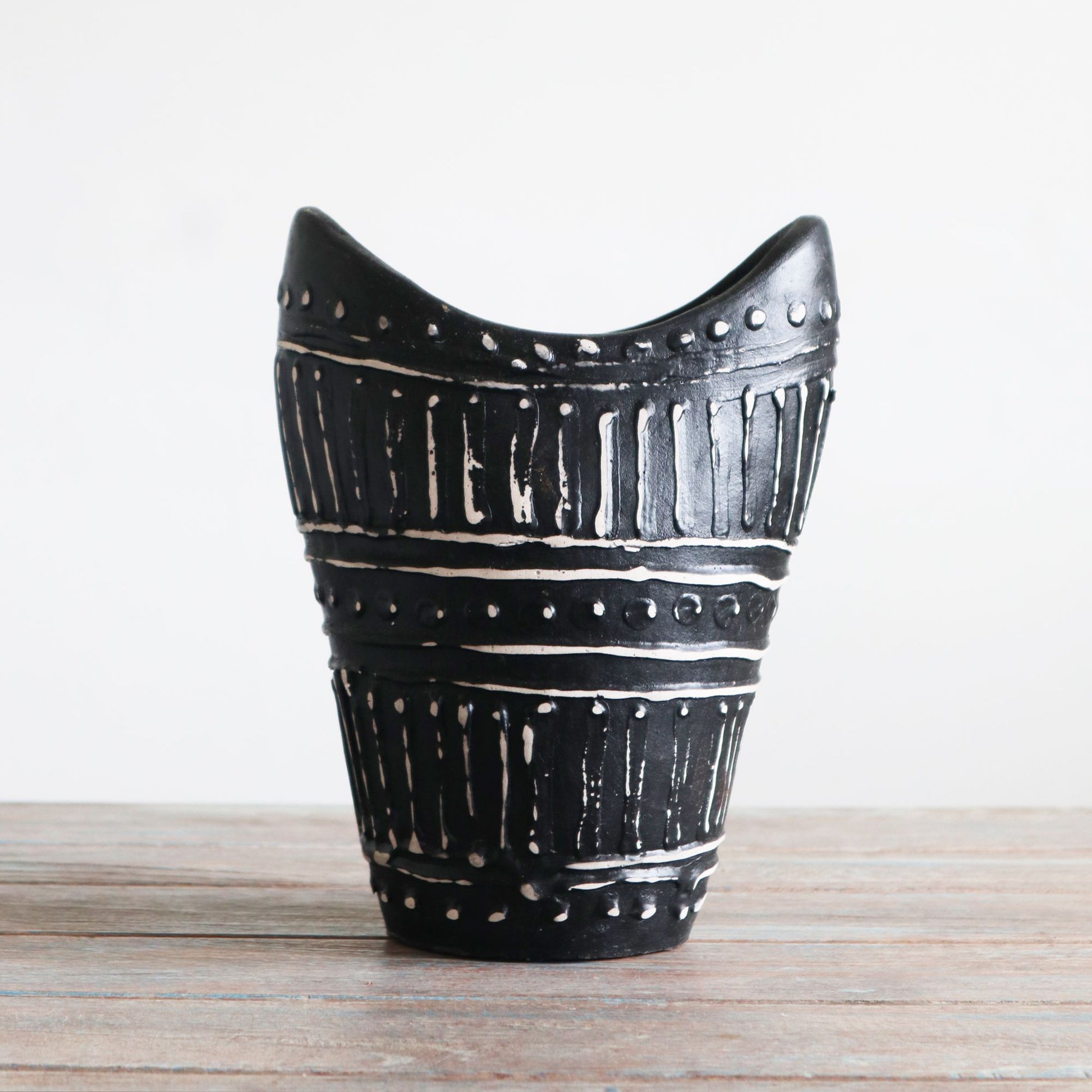 Handcrafted chocolate brown ceramic vase with a unique swirl shape and textured terracotta patterns.