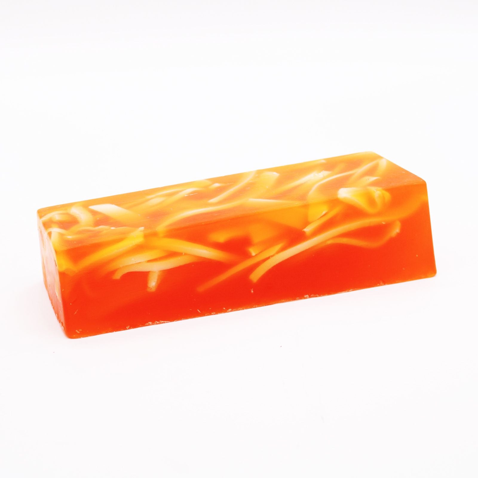 A textured artisanal soap loaf with vibrant orange citrus tones and a natural, rustic finish.