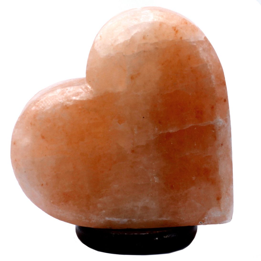 Hand-carved heart-shaped Himalayan salt lamp emitting a warm orange glow on a wooden base.