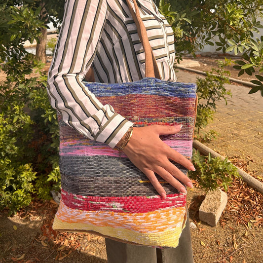 Large patterned tote bag made from recycled rug materials featuring various shades of lavender and purple.