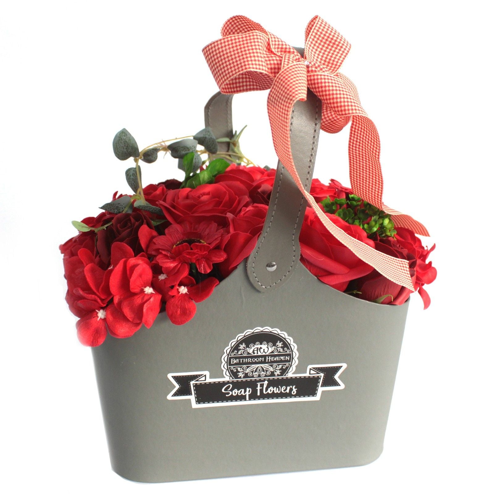 Beautifully arranged red soap flower roses in a wicker basket with decorative greenery and ribbons.