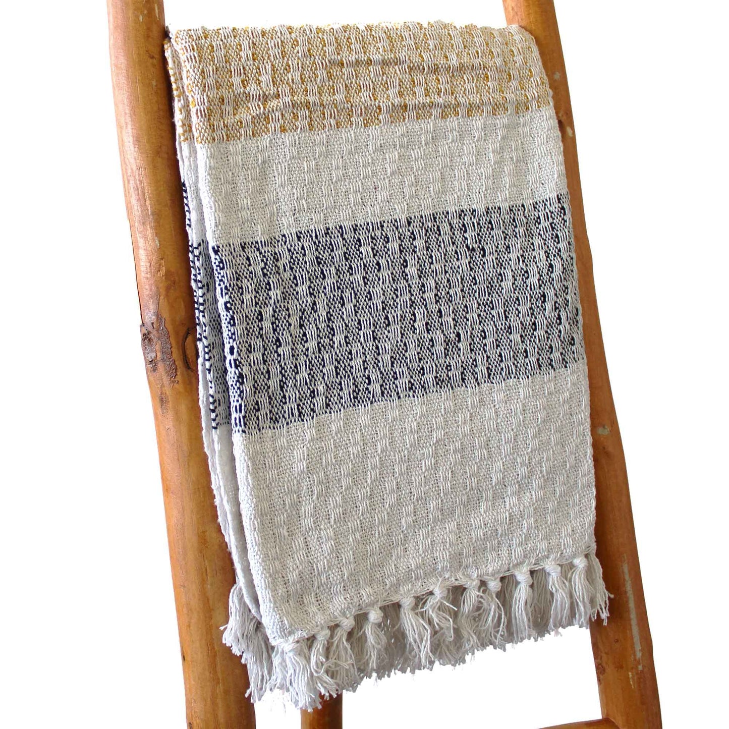 Soft cream cotton throw with golden accents, grey stripes, and decorative tasselled edges on a neutral background.